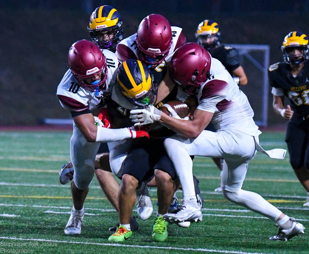 Bellevue High senior Max Jones carries the ball while three Bethel players tackle him. Bethels players are senior Zak Fruean, senior Jayden Miller and sophomore Mason Dutcher. Photo courtesy of Stephanie Ault Justus