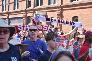 Fans hoist scarves as the march to Seattle Stadium continued. Ben Ray / The Reporter
